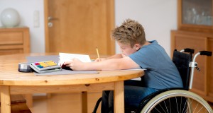 boy in wheelchair doing homework